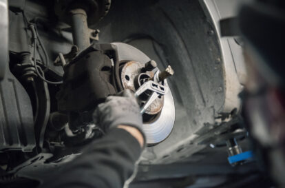 Auto mechanic man with face mask working at auto repair shop, covid-19