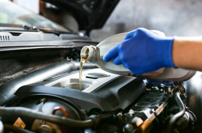 automobile oil is poured into the engine close up. pouring new oil into the engine. car engine oil change