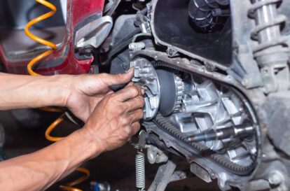 Motorcycle mechanic check the condition of Auto Transmission system or Clutch system of scooter at workshop. Repair and maintenance motorcycle concept.selective focus
