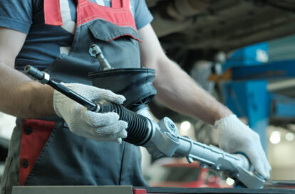 Repair of a passenger car. An auto mechanic monitors the integrity of the new steering rack.