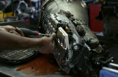 Auto shop owner taking apart his car transmission.