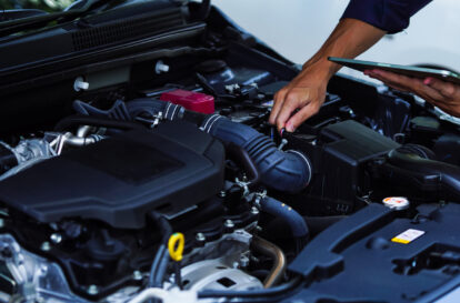 Auto mechanic hands using wrench to repair auto engine. Car maintenance, service at garage. Technician inspects vehicle for problems. Auto repair, fixing, check, services, insurance, checkup concept.