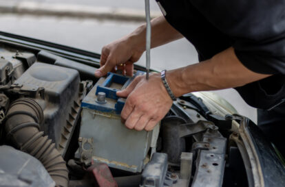 A driver replacing the car battery. Car battery repair and inspection. Repair, maintenance, concept.